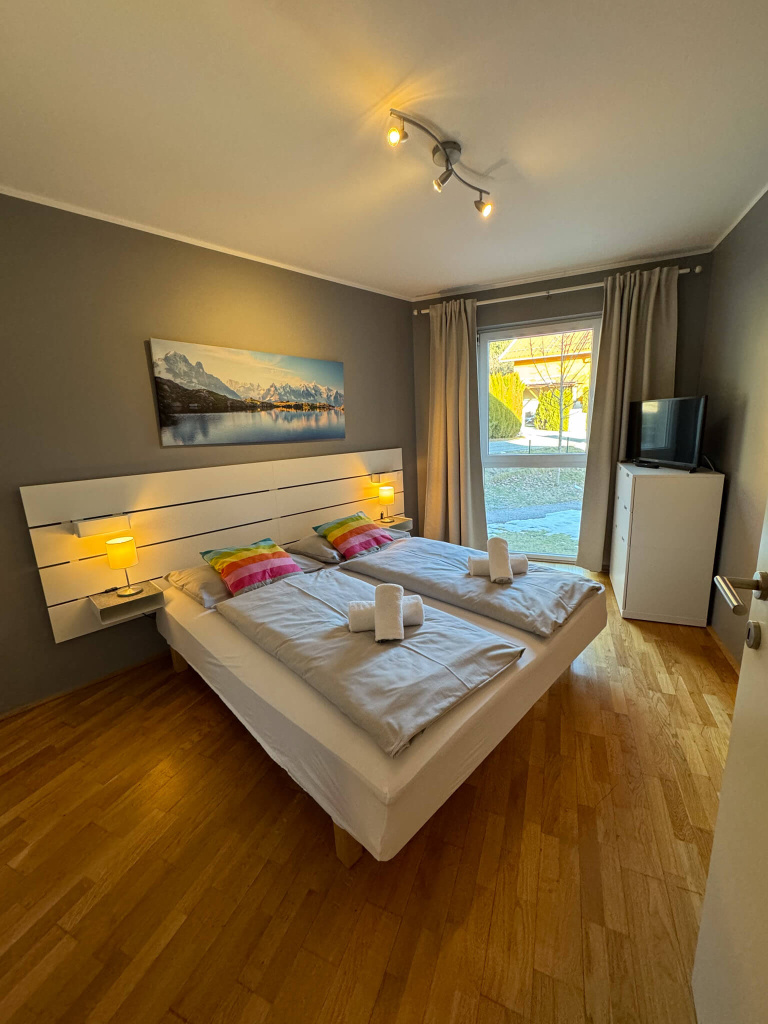Schlafzimmer im Appartement Svea mit Doppelbett, Fernseher und Fensterblick.