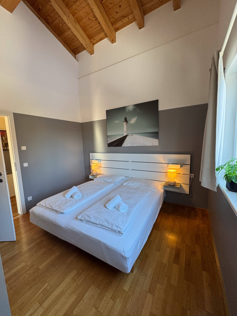 Gemütliches Schlafzimmer im schwedisch-österreichischen Stil mit Holzdecke und warmem Licht.