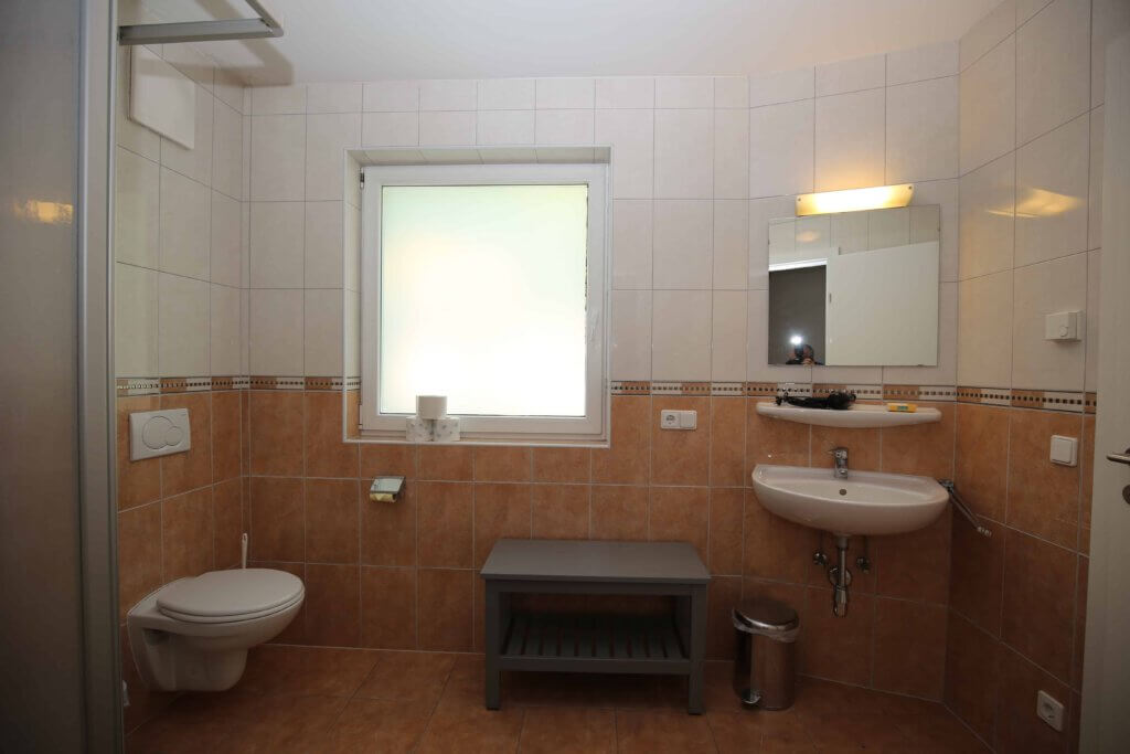 Modernes Badezimmer mit Dusche, Waschbecken und Fenster in Ferienwohnung Haus Vera.